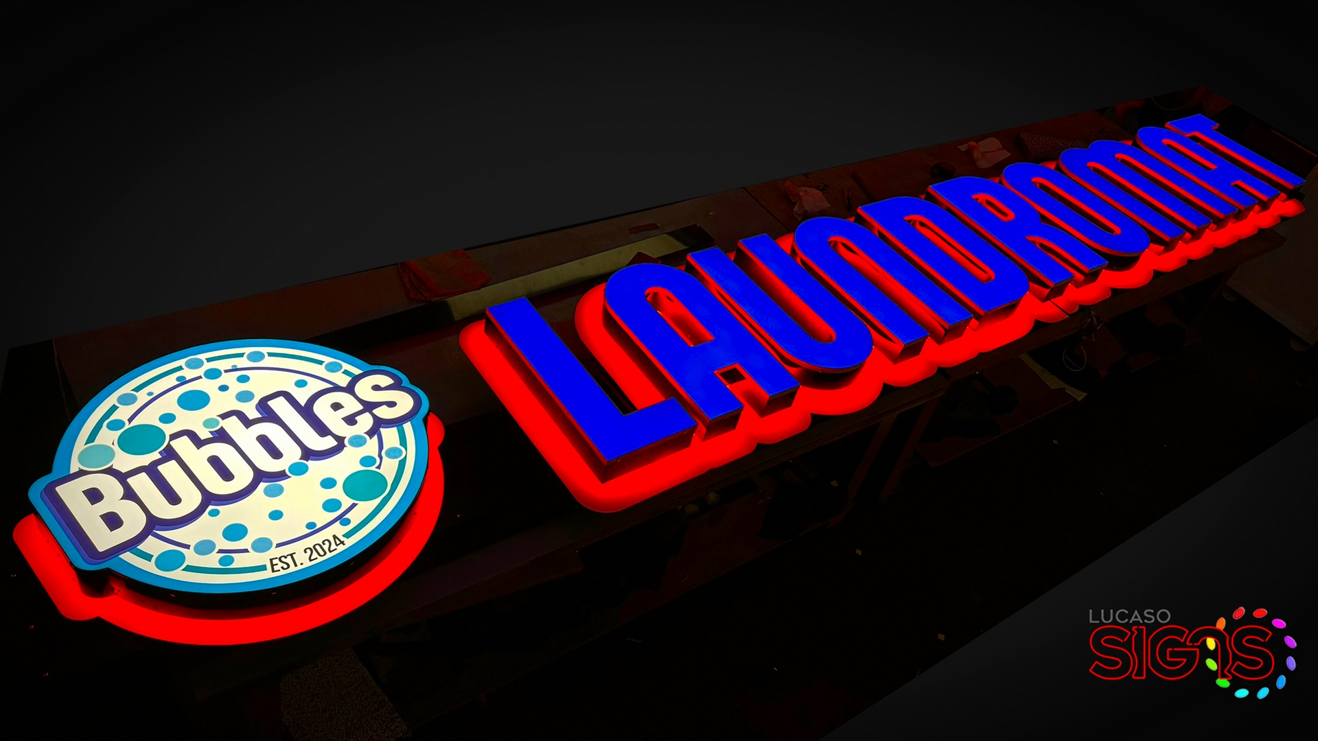 Illuminated channel letter sign for Bubbles Laundromat with blue faces and red LED glow by Lucaso Signs