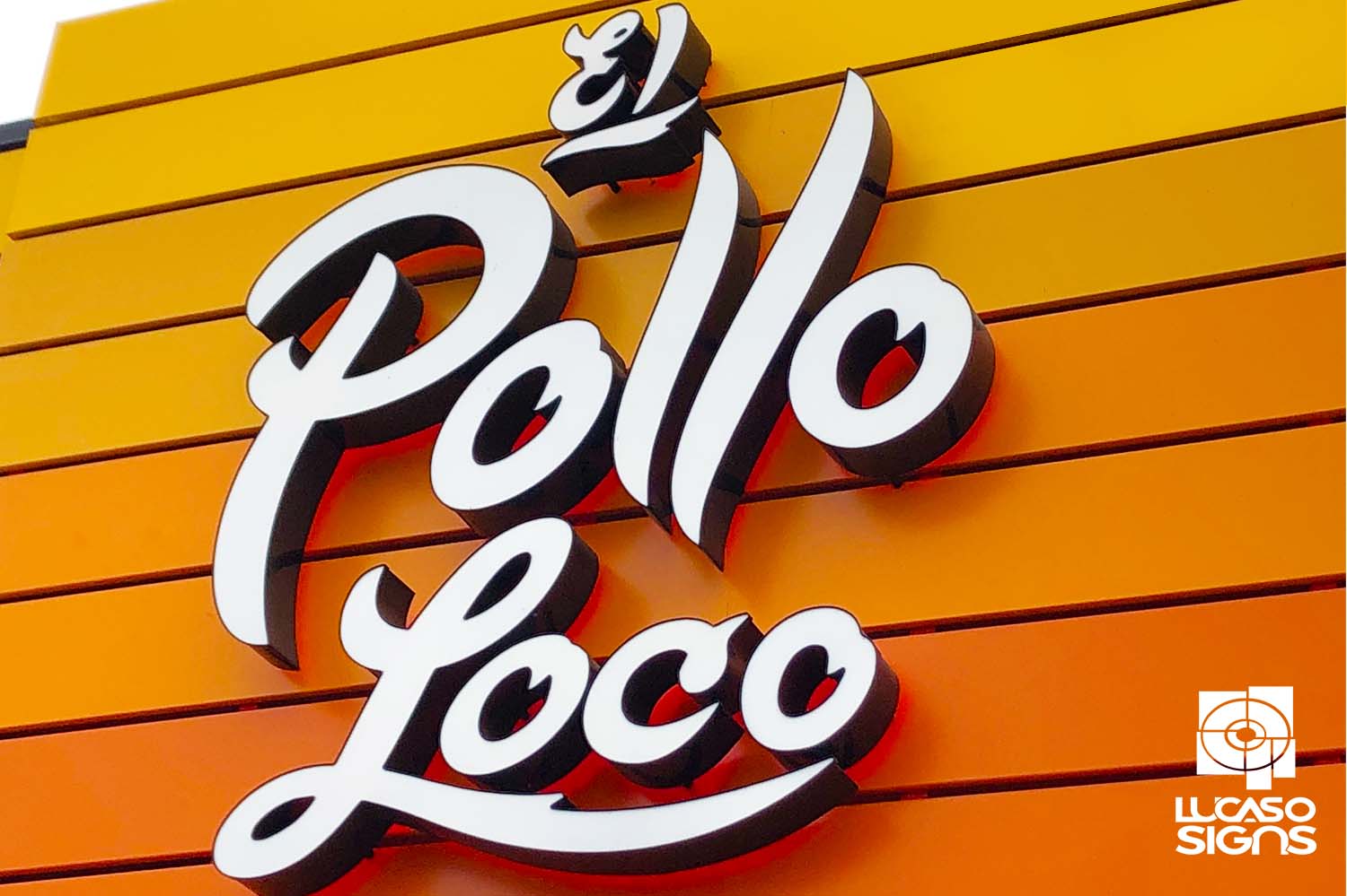 Illuminated white channel letter sign for El Pollo Loco on orange facade by Lucaso Signs