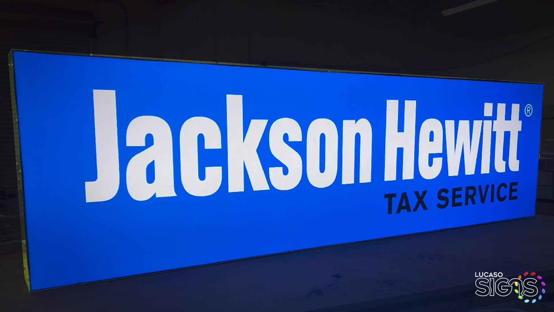 Custom illuminated light box sign with bright blue background and white lettering for Jackson Hewitt Tax Service by Lucaso Signs